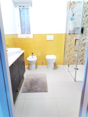 a bathroom with a toilet and a sink and a shower at Casa Vacanze Minù in Faggeto Lario 