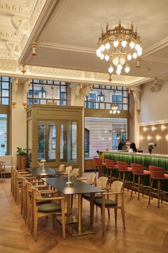 a restaurant with tables and chairs and a chandelier at Palatinus Grand Hotel in Pécs