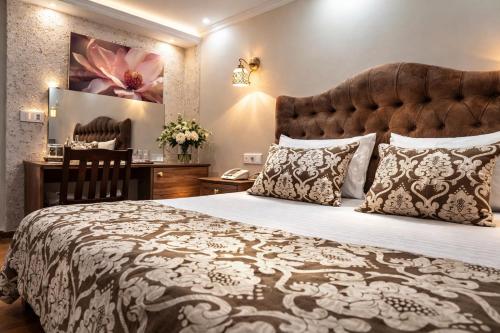 a hotel room with a large bed and a desk at Osmanli Marco Pasha Hotel in Tarsus