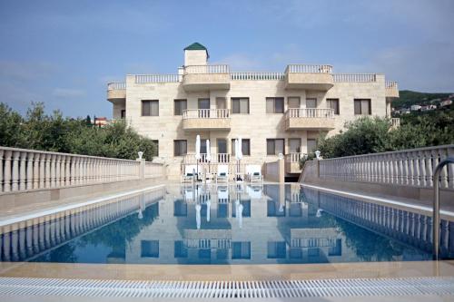 a building with a pool of water in front of it at Villa Olivera Hotel in Tḩūm at Taḩtā
