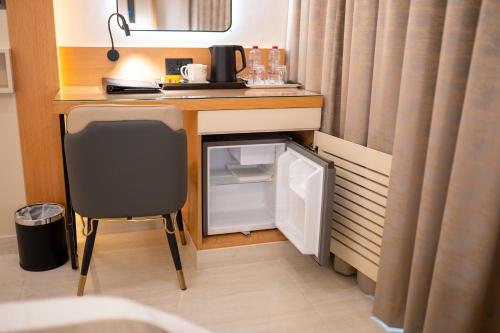 a room with a desk with a refrigerator and a chair at Smana Hotel Al Raffa in Dubai