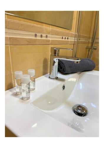 a white bathroom sink with a towel and glasses on it at Mojacar 1ª linea playa vacaciones in Mojácar