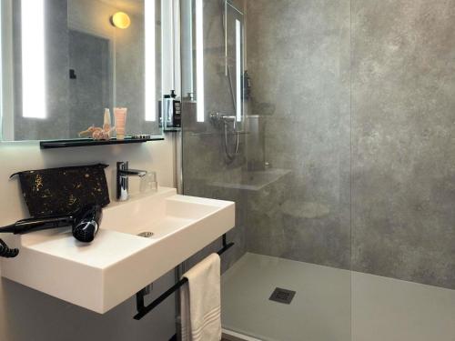 a bathroom with a sink and a shower at ibis Rennes Beaulieu in Cesson-Sévigné
