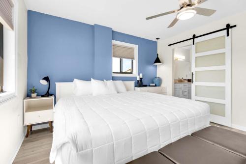 a bedroom with a white bed and a blue wall at Santa Rosa Dunes 721 in Pensacola Beach