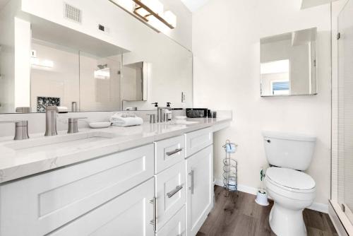 a white bathroom with a toilet and a large mirror at Santa Rosa Dunes 721 in Pensacola Beach