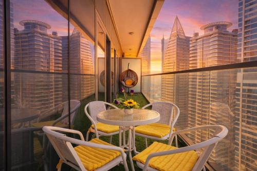 a table and chairs on a balcony with a view of the city at 2BR Burj Khalifa and Sea View Apartments in Paramount Hotel Midtown in Dubai