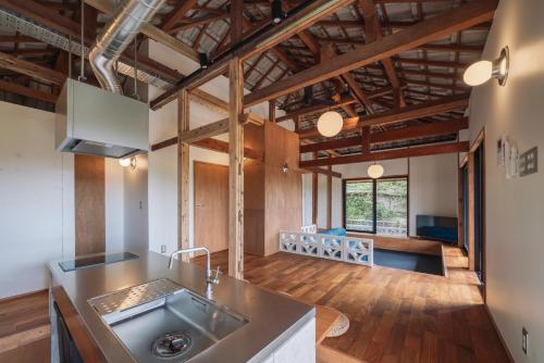 an open kitchen and living room with wooden ceilings at TaaCH Okinawa in Nago
