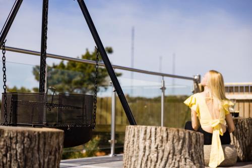 a woman sitting on a bench talking on a cell phone at GrebbestadFjorden glampingpoddar in Grebbestad