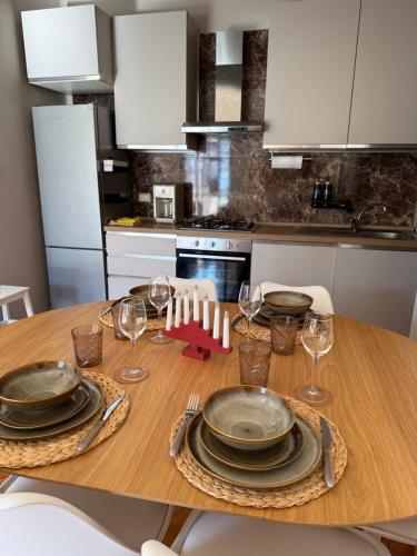 a wooden table with plates and wine glasses on it at Villa Montepaone in Montepaone Lido