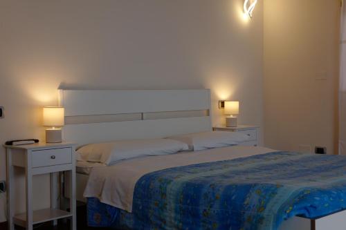 a bedroom with a large bed with two lights on it at B & B Paradiso in Loreto