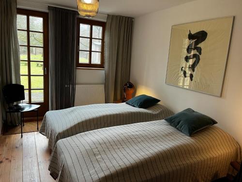 a bedroom with two beds and a picture on the wall at Atelier-Turm in Gschwend