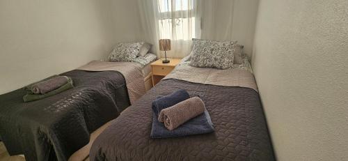 two beds in a small room with two pillows on them at Sunny Hill Apartment in Ciudad Quesada