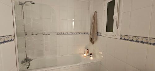 a bathroom with a tub and a shower with candles at Sunny Hill Apartment in Ciudad Quesada