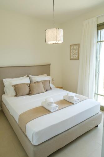 a large white bed with two towels on top of it at Villa Artemis 1 - Etheras Properties in Kythira