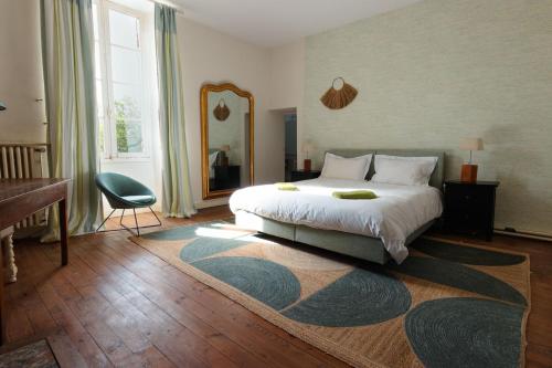 a bedroom with a bed and a desk and a mirror at Beaulieu Saint Come in Saint-Côme