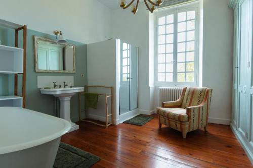 a bathroom with a sink and a chair and a mirror at Beaulieu Saint Come in Saint-Côme