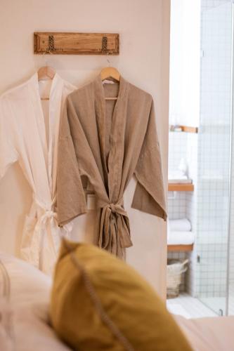 a robe hanging on a rack in a bedroom at Kolonie's Tuin in Stellenbosch