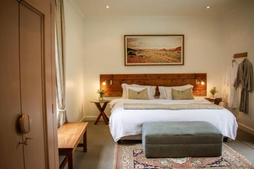 a bedroom with a large white bed and a rug at Kolonie's Tuin in Stellenbosch