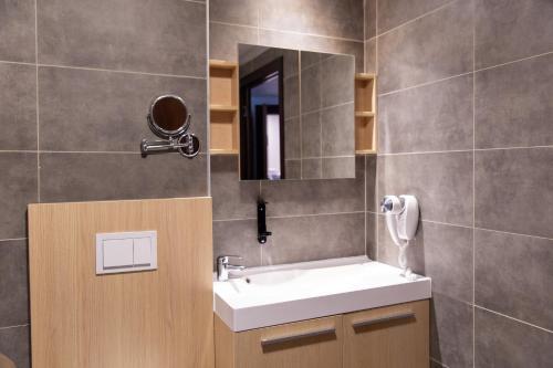a bathroom with a sink and a mirror at Zenitude Swiss Apparthotels in Ferney-Voltaire