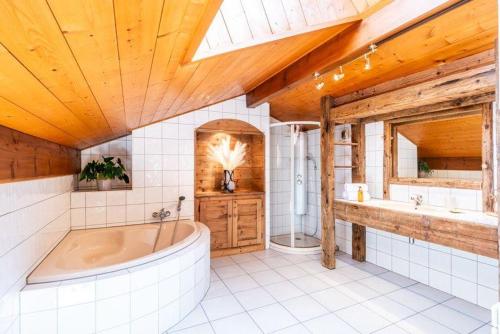 a large bathroom with a tub and a sink at Ecrin des anges in Vacheresse