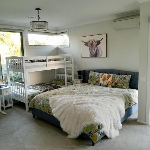 a bedroom with a bed and two bunk beds at Luxury House Boho Seaside in Cowes