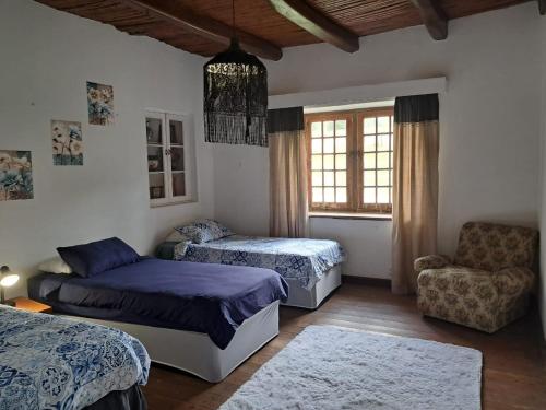 a bedroom with two beds and a couch and a chair at Klipfontein Rustic Farm & Camping in Tulbagh