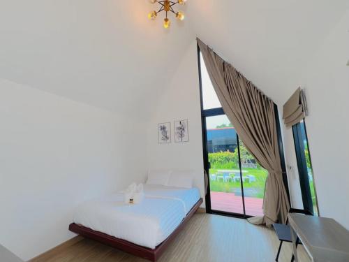 a bedroom with a bed and a large window at Nordic SkyBird Hill Chill in Pak Chong
