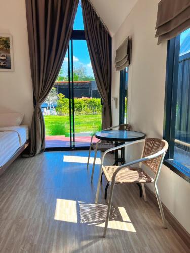a room with a table and chairs and a bed at Nordic SkyBird Hill Chill in Pak Chong