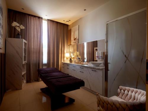 a bathroom with a sink and a couch in it at Imperiall Resort & MediSpa in Ustronie Morskie
