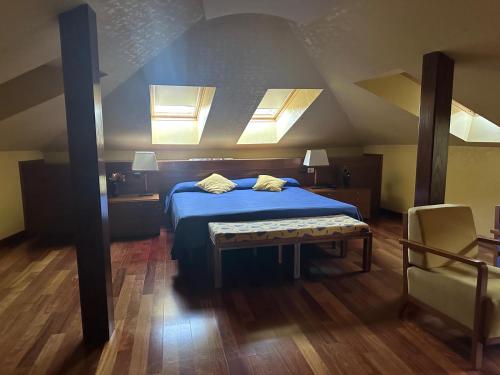 a bedroom with a blue bed with two pillows on it at Hotel Vado del Duratón in Sepúlveda