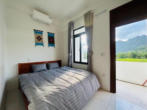 a bedroom with a bed and a large window at Bao An Homestay Mai Chau in Mai Châu