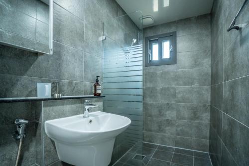 a bathroom with a white sink and a shower at Joohane Jejudo House in Jeju