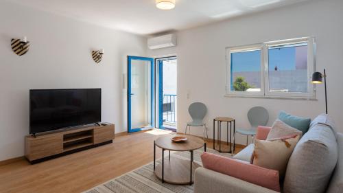 a living room with a couch and a flat screen tv at Villa Marie e Villa Marieke Ferragudo by Rosado in Ferragudo