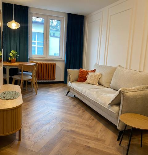 a living room with a couch and a table at ZIELONE DRZWI Hajnówka in Hajnówka