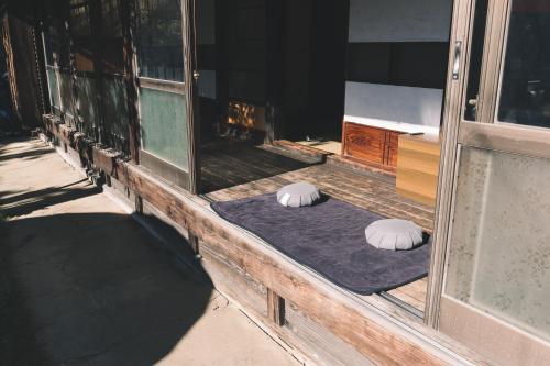 two white pillows sitting on a porch next to a window at JIKON SAUNA Tokyo in Ome
