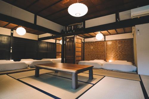 a room with white beds and a wooden table at JIKON SAUNA Tokyo in Ome