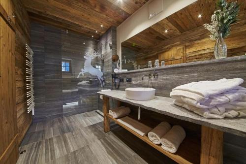 a bathroom with a sink and a counter with towels at Panorama Chalets by we rent, JOKERCARD INCLUDED in Saalbach-Hinterglemm