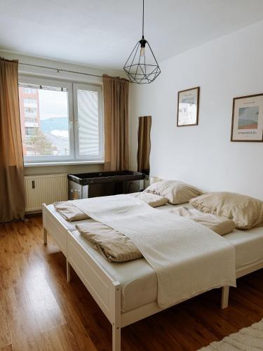 a bedroom with two beds and a piano at Apartmán Mierová in Stará Ľubovňa