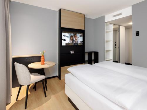 a bedroom with a bed and a table and a chair at smartments Bielefeld Hauptbahnhof in Bielefeld