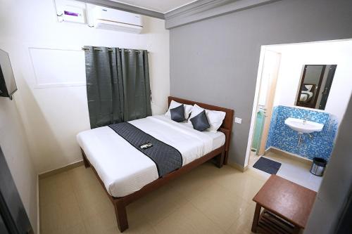 a bedroom with a bed and a bathroom with a sink at Blessings select DLF in Chennai