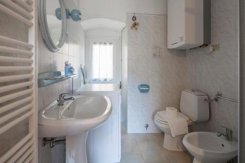 a white bathroom with a sink and a toilet at Beautiful view apartment Riomaggiore, Cinque Terre in Riomaggiore