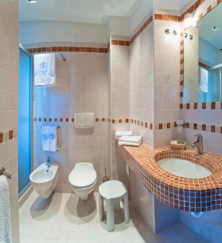 a bathroom with a sink and a toilet and a tub at Hotel Europa in Bibione