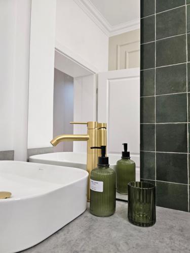a bathroom with two green bottles next to a sink at ISHotel in Craiova