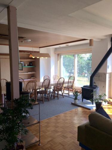a living room with a table and chairs and a fireplace at Muikamachi Hutte in Minami Uonuma