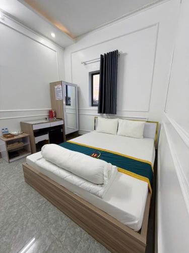 a large bedroom with two beds and a desk at NHÀ NGHỈ LÊ ĐƯỢC 2 in Hà Tiên