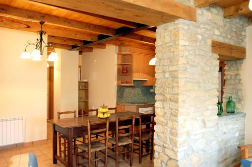 kuchnia i jadalnia ze ścianą z kamienia w obiekcie Casa Ros w mieście Agullo