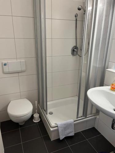 a bathroom with a shower and a toilet and a sink at Hotel Landhaus Adensen in Nordstemmen