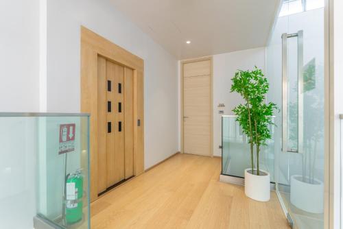 a hallway with a potted plant and a door at Heaven Thonglor 36 - Villa in Bangkok