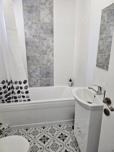 a white bathroom with a tub and a sink at At Ladyluck in Suceava