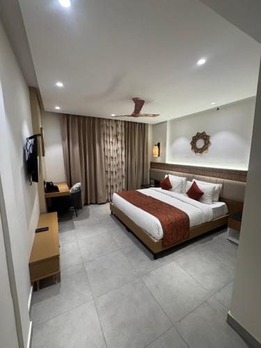 a hotel room with a bed and a television at Divine OAK Stay in Narendranagar